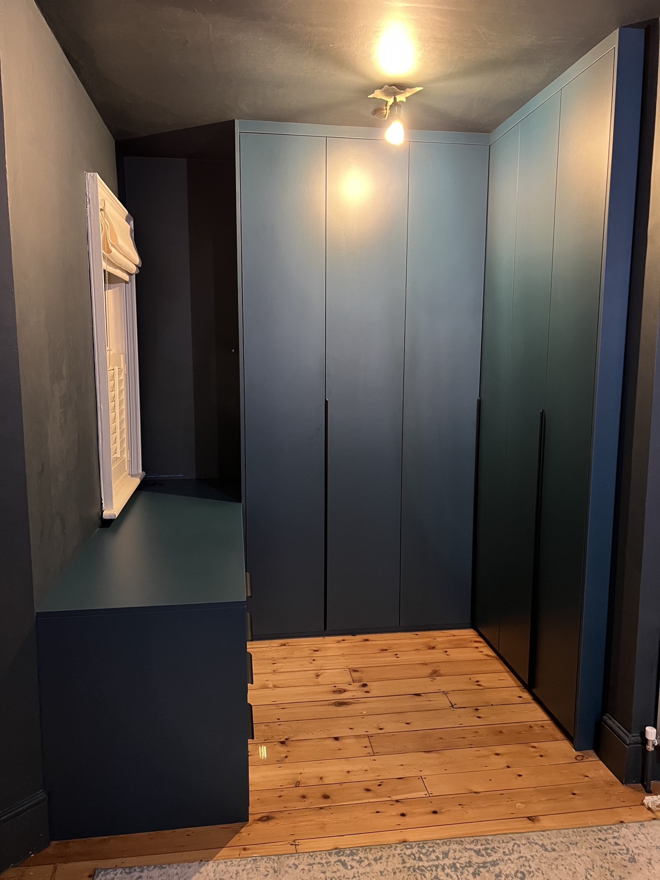Completed deep blue fitted wardrobes in a dressing area
