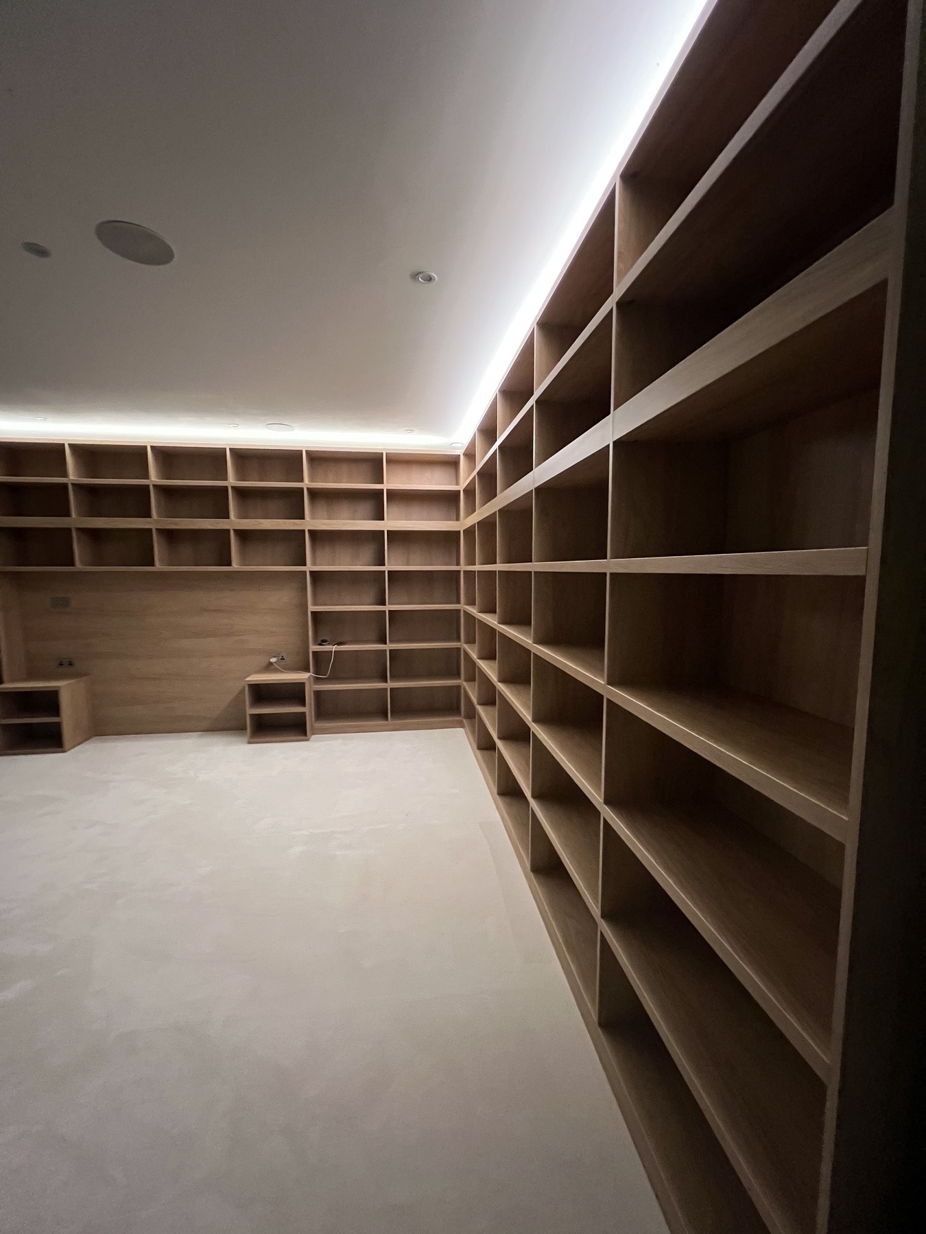 Completed wraparound shelving installation in a warm oak-effect finish